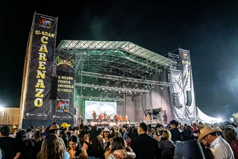 Cantante con sombrero blanco saludando desde el escenario